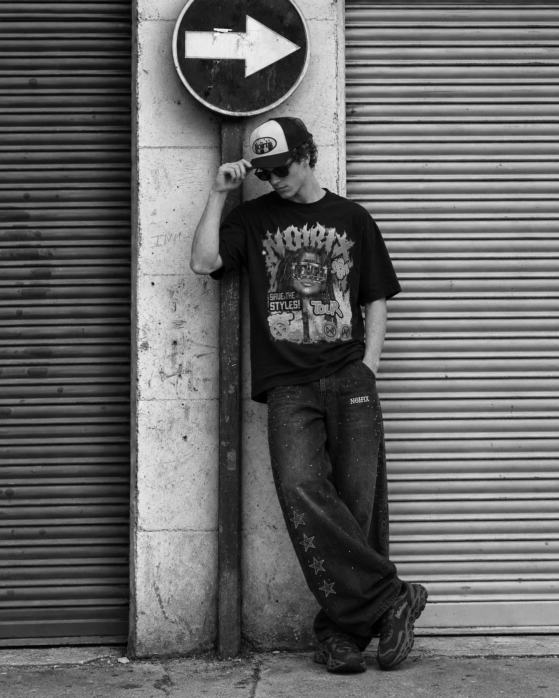 Model wearing the black Styles Tour tee, rhinestone jeans and a NOIRIX trucker cap